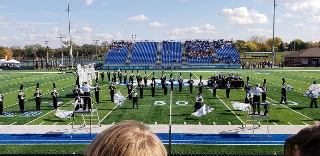 Marching band on field Performing Tree of Life show